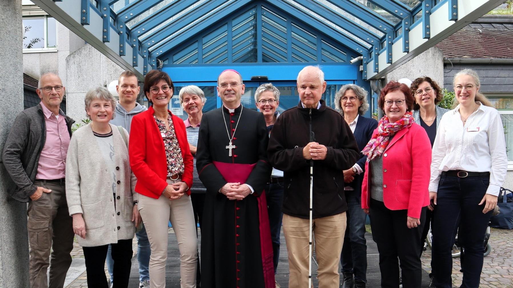 Weihbischof Robert Brahm (Mitte) tauscht sich mit ehrenamtlichen „Grünen Damen und Herren“ im DRK Krankenhaus Kirchen aus. Es fehlen auf dem Foto weitere langjährige Ehrenamtliche.